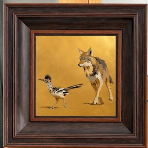 Peut inclure: Une peinture carrée encadrée représentant un grand géocoucou et un coyote sur un fond doré uni. L'œuvre est insérée dans un cadre en bois brun foncé avec un bord biseauté profond, montrant les deux animaux de profil.