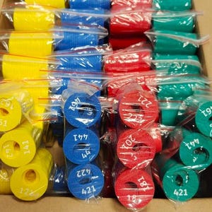 May include: Assortment of colorful foam rings in yellow, blue, red, and green, packaged in clear plastic bags. Each ring is labeled with a white number. The rings are stacked inside a cardboard box.