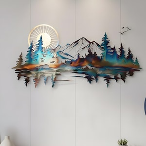 Puede incluir: Arte mural de metal que representa un paisaje montañoso con árboles, un lago y un sol. La obra de arte presenta un degradado de color de azules, verdes y naranjas. El sol es un diseño circular con líneas radiantes. Dos pájaros vuelan en la parte superior derecha.