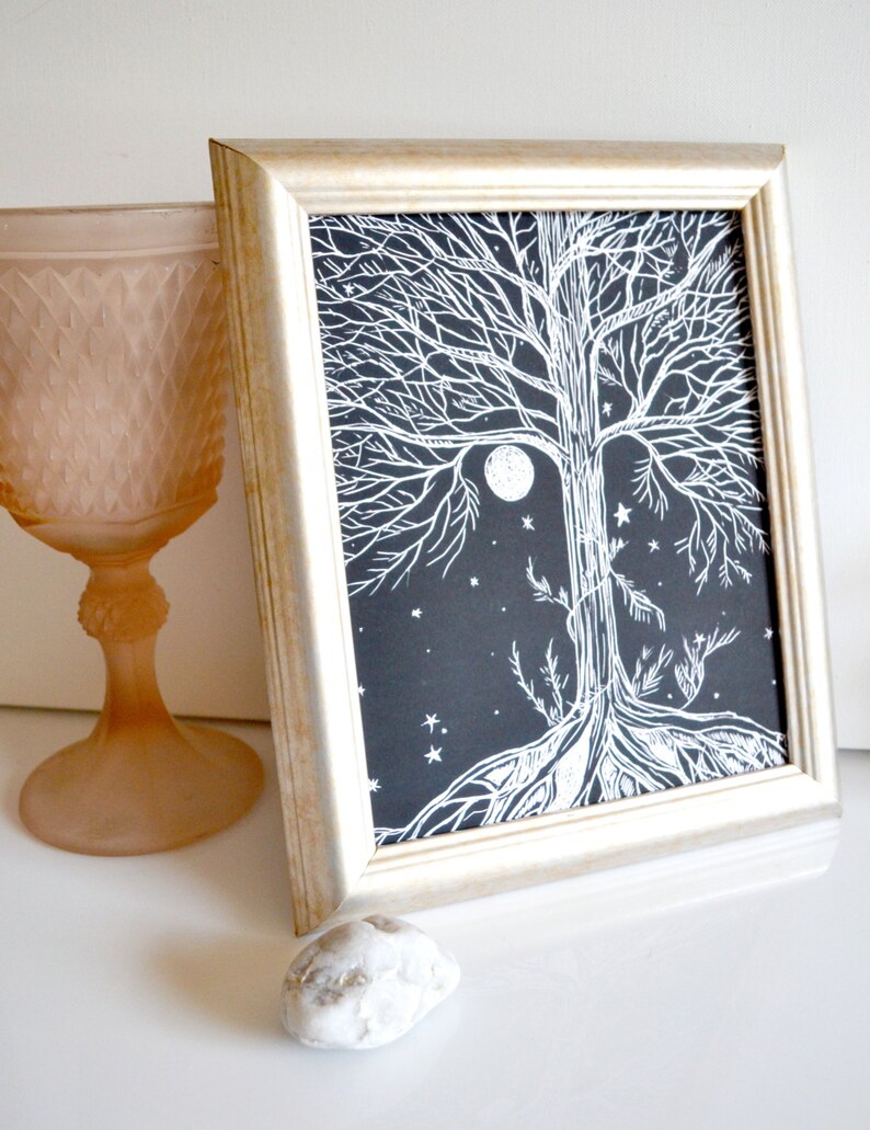 Puede incluir: Una impresi&oacute;n enmarcada en blanco y negro de un &aacute;rbol con una luna llena y estrellas en el fondo. El &aacute;rbol est&aacute; estilizado con intrincadas ramas y ra&iacute;ces.