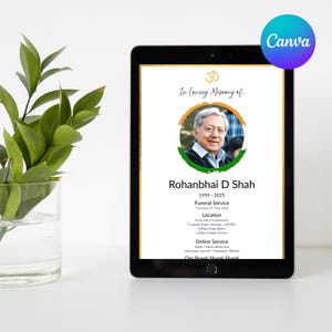 May include: A digital tablet displays a memorial announcement. The text reads "In Loving Memory of... Rohanbhai D Shah 1959-2025." The announcement includes a photo, service details, and an online service link. A green plant in a glass vase is in the background.