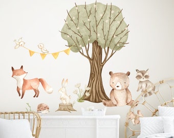 Puede incluir: Un conjunto de pegatinas de pared de animales del bosque que incluyen un zorro, un oso, un conejo, un mapache, pájaros y un árbol con una pancarta. Las pegatinas son de estilo acuarela con colores marrón, verde y naranja.
