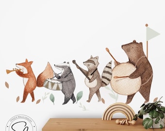 Puede incluir: Ilustración en acuarela de una banda de animales del bosque. Un zorro toca la trompeta, un tejón toca la batería, un mapache toca el banjo y un oso toca un tambor grande. El fondo es blanco con hojas verdes.