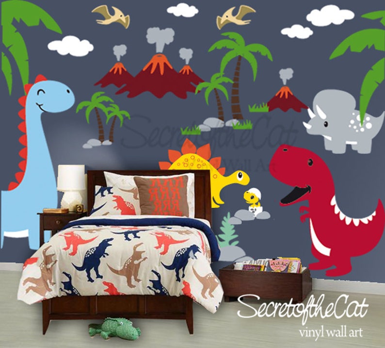 May include: A bedroom featuring a bed with a dinosaur-patterned comforter and a dark wood headboard. The wall displays vinyl wall art of volcanoes, palm trees, clouds, and various colorful dinosaurs including a blue, yellow, and red one.