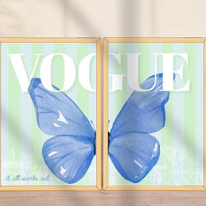 May include: Two framed art prints featuring a blue watercolor butterfly with the word "VOGUE" in white. The background has vertical stripes in light green and blue. The phrase "it all works out" is at the bottom.