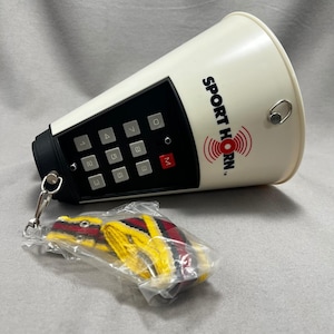 May include: A white and black Sport Horn with a keypad and the text "Sport Horn". A red and yellow whistle is attached to the horn with a silver chain. The horn is designed to amplify sound.