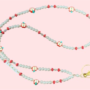 Cordón para credencial de profesor. ¡Un regalo para el profesor! Cordón con cuentas de perla y manzana. Sin personalización ni variación del dije con la palabra &quot;TEACH&quot;.