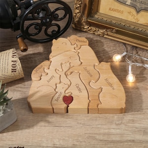 Peut inclure: Puzzle familial en bois en forme d'ours. Chaque ours est grav&eacute; d'un nom, avec un c&oelig;ur rouge au centre. Les noms incluent Daniel, Millie, Avery, Jennie, Jackson, Carter et Matthew.