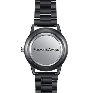 May include: A black wristwatch with a metal strap and a circular face. The watch face is silver with the words "Forever & Always" printed in black. The watch has a modern design.