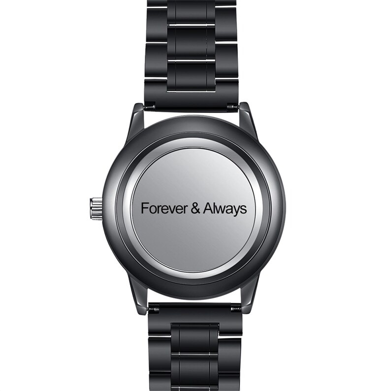 May include: A black wristwatch with a metal strap and a circular face. The watch face is silver with the words "Forever & Always" printed in black. The watch has a modern design.