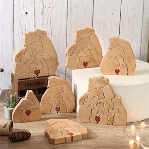 Peut inclure: Puzzles en bois repr&eacute;sentant des familles d'ours avec des noms grav&eacute;s et un c&oelig;ur rouge. Les puzzles sont en bois clair et pr&eacute;sentent plusieurs ours. Les noms sont grav&eacute;s en cursive. Les puzzles sont expos&eacute;s sur une surface en bois.
