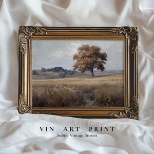 May include: A rectangular landscape painting in a dark brown and gold ornate frame. The artwork depicts a solitary tree in a golden field under a cloudy sky. Below the frame, the text reads VIN ART PRINT Subtle Vintage Stories.