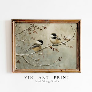 May include: A framed vintage art print depicting two small birds on a snow-covered branch. The birds have black and white heads and tan bodies. The artwork has a muted colour palette. The text "VIN ART PRINT" and "Subtle Vintage Stories" is at the bottom.