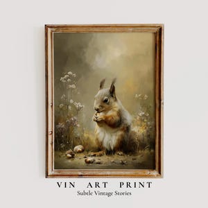 May include: A framed vintage art print showing a squirrel holding a nut, set in a naturalistic scene with wildflowers and acorns. The artwork has a warm, earthy colour scheme. The print includes the text "VIN ART PRINT" and "Subtle Vintage Stories".