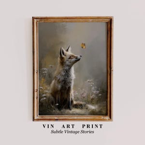 May include: A framed art print featuring a fox gazing at a butterfly. The fox is depicted in shades of brown and tan, sitting amidst wildflowers. The print has a vintage aesthetic, with the text "VIN ART PRINT" and "Subtle Vintage Stories".
