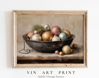May include: A vintage print depicting a still life of Christmas baubles in a dark bowl. The baubles are in various colours, including gold, silver, and pink. A pine cone and greenery are also in the bowl. The print is framed in a light-coloured wooden frame.