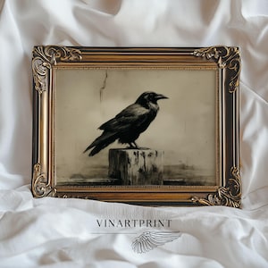 Op de afbeelding: Een ingelijste kunstdruk met een zwarte raaf op een houten paal. Het kunstwerk zit in een sierlijke, donkerbruine en goudkleurige lijst met decoratieve hoekdetails. De tekst VINARTPRINT is zichtbaar onder de lijst.