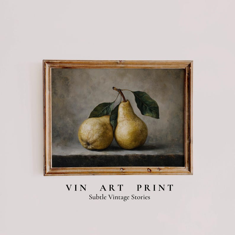 May include: A framed art print featuring a still life painting of two yellow pears with green leaves on a dark surface against a muted gray background. The text VIN ART PRINT Subtle Vintage Stories is printed below the frame in black lettering.