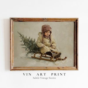 Op de afbeelding: Een vintage kunstafdruk in een houten lijst. De afbeelding toont een kind in winterkleding op een houten slee, die een kleine dennenboom trekt. Het kunstwerk gebruikt een gedempte kleurenpalet van beige, bruin en groen. De lijst is van hout.