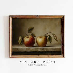 May include: A framed vintage art print featuring two apples with leaves. One apple is red, the other is yellow. The print has a warm color palette and the text "VIN ART PRINT" and "Subtle Vintage Stories" at the bottom.