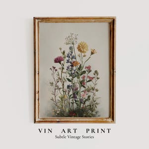 Könnte beinhalten: Ein gerahmter Kunstdruck mit einer Aquarellillustration von Wildblumen in Lila, Gelb, Rosa und Blau. Der Druck befindet sich in einem Holzrahmen im Vintage-Stil. Der Text "VIN ART PRINT" und "Subtle Vintage Stories" befindet sich unten.