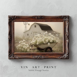 May include: A framed print featuring a sepia-toned rural scene. A white barn with a black roof and a windmill are in the background. A wheelbarrow overflowing with white daisies is in the foreground. The frame is dark brown. Text at the bottom reads "VIN ART PRINT" and "Subtle Vintage Stories".
