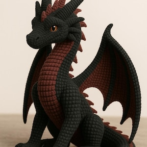 Puede incluir: Figura de dragón de ganchillo hecha a mano en negro y burdeos. El dragón tiene escamas, cuernos y alas detalladas. Los ojos son de un marrón cálido. El dragón está sentado con las alas extendidas, mostrando el intrincado diseño y la artesanía.