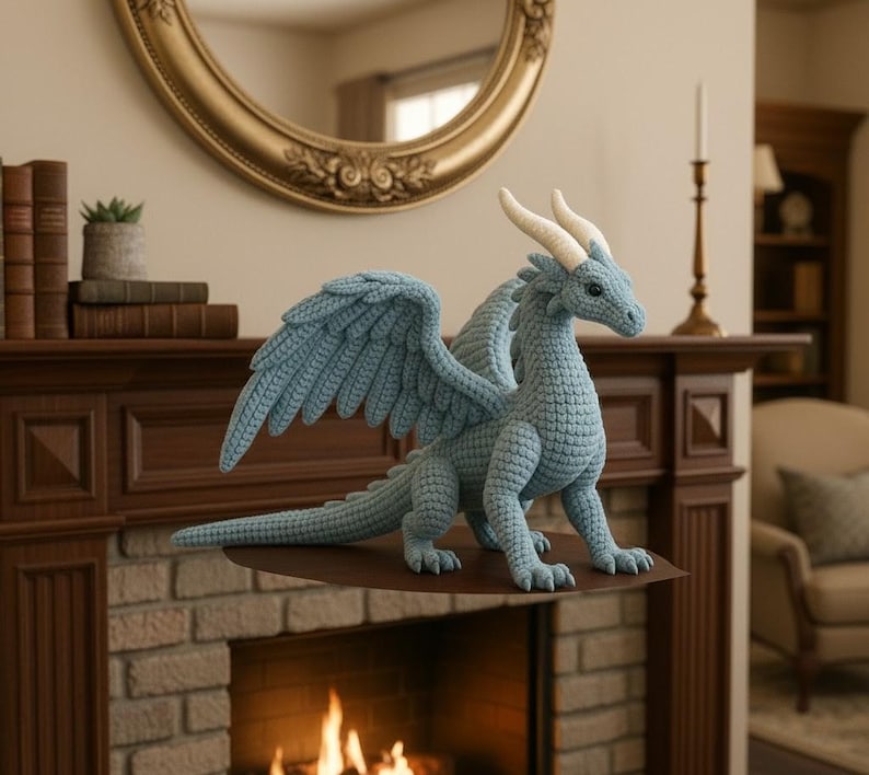 May include: A light blue crocheted dragon figurine with large wings, white horns, and a long tail. The dragon is displayed on a brown shelf in front of a brick fireplace. The dragon is a decorative item.