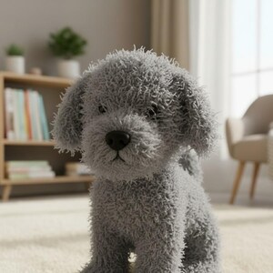 May include: A soft, grey dog toy with a fluffy, textured finish. The toy has a black nose and is positioned on a light-coloured carpet. A wooden bookshelf and chair are visible in the background.