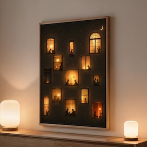 Può includere: Una stampa artistica incorniciata raffigura una scena notturna con molte finestre illuminate su uno sfondo scuro. Nelle finestre si vedono sagome di persone. Due lampade bianche e luminose sono su una cassettiera di legno.
