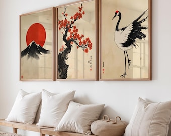 May include: Three framed Japanese-style art prints. The prints feature a red sun over a mountain, a flowering tree, and a crane. The artwork is in a minimalist style with a neutral color palette and wooden frames.