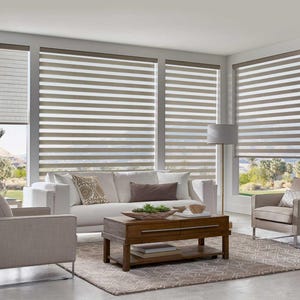 May include: A modern living room with a white sofa, two armchairs, and a wooden coffee table. The windows are covered with horizontal blinds in shades of white and brown. A floor lamp and decorative pillows complete the scene.
