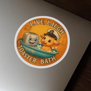May include: A round sticker with a whimsical design. It features a cartoon toaster and a lamb in a teal bathtub with bubbles. The text "LIVE, LAUGH" arches above, and "TOASTER BATH" curves below. The background is orange.