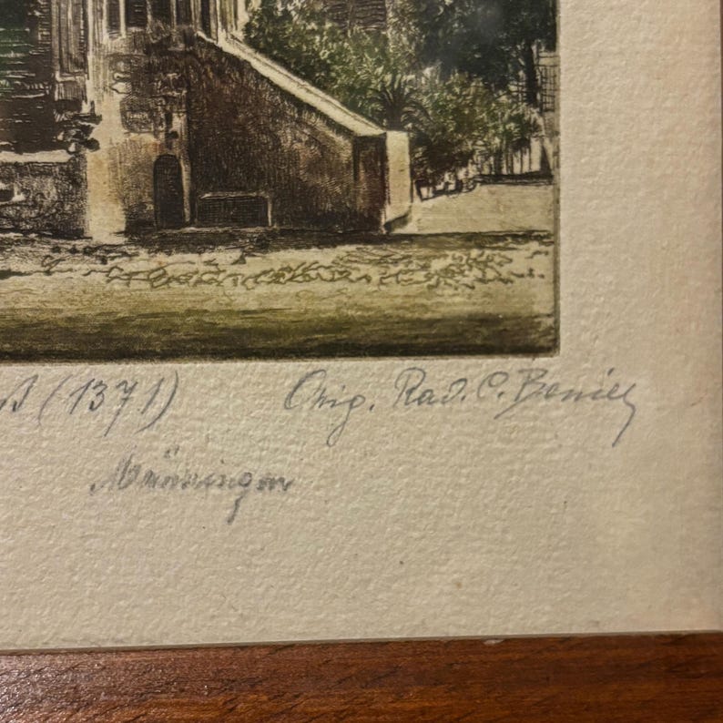May include: An antique print depicting a building with a staircase and foliage. The print, in a wooden frame, features handwritten text, including "Ra. C. Beniey". The artwork uses brown, green, and beige tones, suggesting an aged aesthetic.