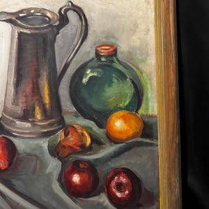 May include: Oil painting of a still life featuring a silver pitcher, a green bottle, and several fruits. The fruits include oranges and red apples. The painting has a muted color palette with a wooden frame.