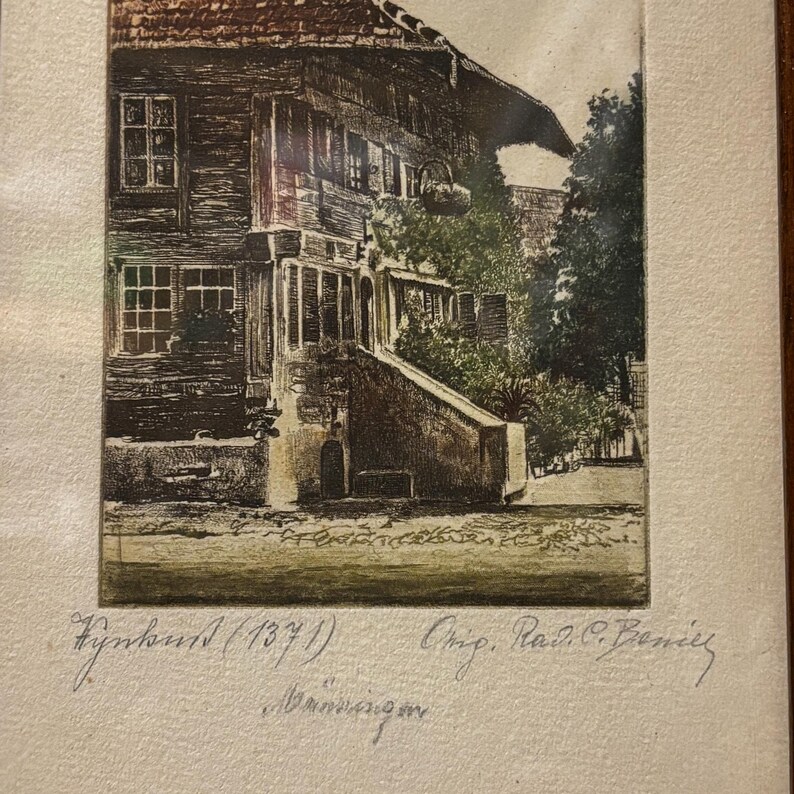 May include: A sepia-toned antique print depicting a wooden building with a pitched roof, windows, and a staircase. The print includes handwritten text at the bottom, with the year 1871. The artwork is framed.