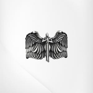 May include: A silver ring depicting an angel with spread wings and a sword. The ring has detailed feather textures and a central figure holding the sword. The ring is set against a white background.