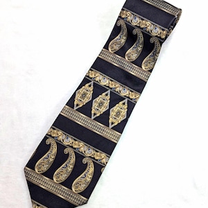 May include: A black necktie featuring a repeating pattern of gold and blue paisley motifs, ornate diamond-shaped emblems, and horizontal decorative bands. The design is arranged in alternating rows across the length of the fabric.