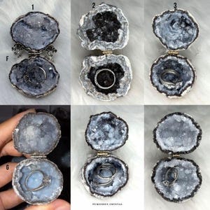 Puede incluir: Seis cajas para anillos de geoda abiertas con cierres met&aacute;licos de bisagra. Cada geoda presenta un centro hueco revestido con cristales brillantes azules o gris oscuro. Varias cajas contienen anillos de metal plateado en su interior.