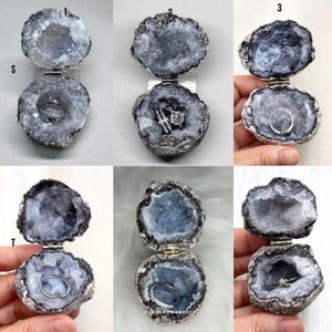 Puede incluir: Una colecci&oacute;n de seis cajas para anillos de geoda con bisagras, cada una con un exterior gris oscuro rugoso y un interior cristalino gris claro brillante. Cada geoda est&aacute; equipada con una bisagra de metal para abrir y cerrar.