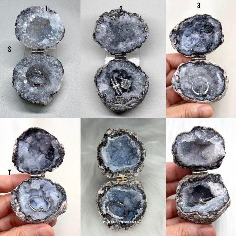 Puede incluir: Una colecci&oacute;n de seis cajas para anillos de geoda con bisagras, cada una con un exterior gris oscuro rugoso y un interior cristalino gris claro brillante. Cada geoda est&aacute; equipada con una bisagra de metal para abrir y cerrar.