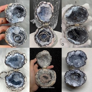 Puede incluir: Una colecci&oacute;n de seis cajas para anillos de geoda abierta, cada una con un exterior oscuro y rugoso y un interior hueco revestido de cristales azul gris&aacute;ceos brillantes. Algunas cajas contienen anillos o una pulsera de cuentas.