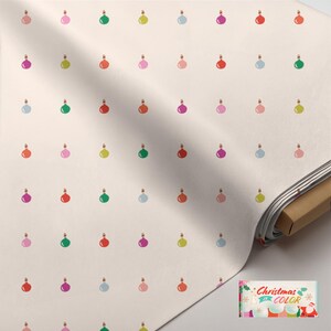 May include: A bolt of off-white fabric featuring a repeating pattern of small, colorful Christmas ornaments in shades of red, green, pink, blue, and yellow. A small rectangular label in the corner displays the text Christmas in Color.