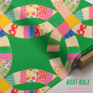 May include: A bolt of fabric featuring a vibrant green background with a repeating double wedding ring quilt pattern. The rings are composed of various colorful patches including floral, plaid, and geometric prints. Text reads BOAT RACE Heather Ross FOR WINDHAM FABRICS.