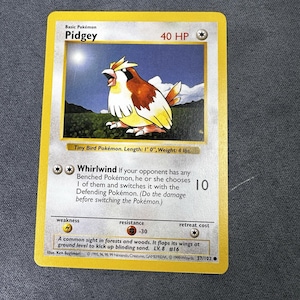 May include: A Pidgey trading card from the base set featuring a brown and cream bird illustration, 40 HP, and the Whirlwind attack. The card includes text detailing the Tiny Bird Pokémon, its 1' 0" length, 4 lbs weight, and game statistics.