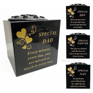 May include: Black memorial urns with gold heart designs and text. One urn reads "Special Dad," another "Special Son," a third "Special Partner," and a fourth "Special Nan." Each urn has a different message.