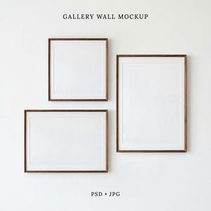 May include: A gallery wall mockup featuring three empty picture frames with dark wood borders. The arrangement includes one square frame, one horizontal rectangular frame, and one vertical rectangular frame. The text GALLERY WALL MOCKUP PSD JPG appears.