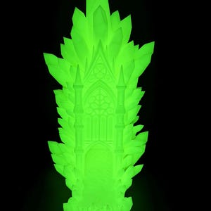 May include: A glowing green sculpture of a gothic cathedral with a crystal-like structure. The sculpture features a detailed facade with arched windows and spires, set against a black background. The overall design evokes a fantasy or mystical theme.