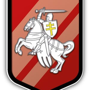 Może przedstawiać: Emblemat w kształcie tarczy przedstawiający białego rycerza na koniu, dzierżącego miecz. Tarcza rycerza jest żółta z krzyżem. Tło ma czerwone i brązowe ukośne paski z czarną obwódką.