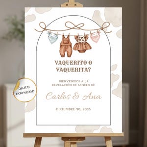 May include: A digital download sign on an easel for a gender reveal party. The sign features a rope with baby clothes hanging from it. The text reads "Vaquero o Vaquerita?" and "Bienvenido a la revelación de género de Carlos & Ana, Diciembre 20, 2025."